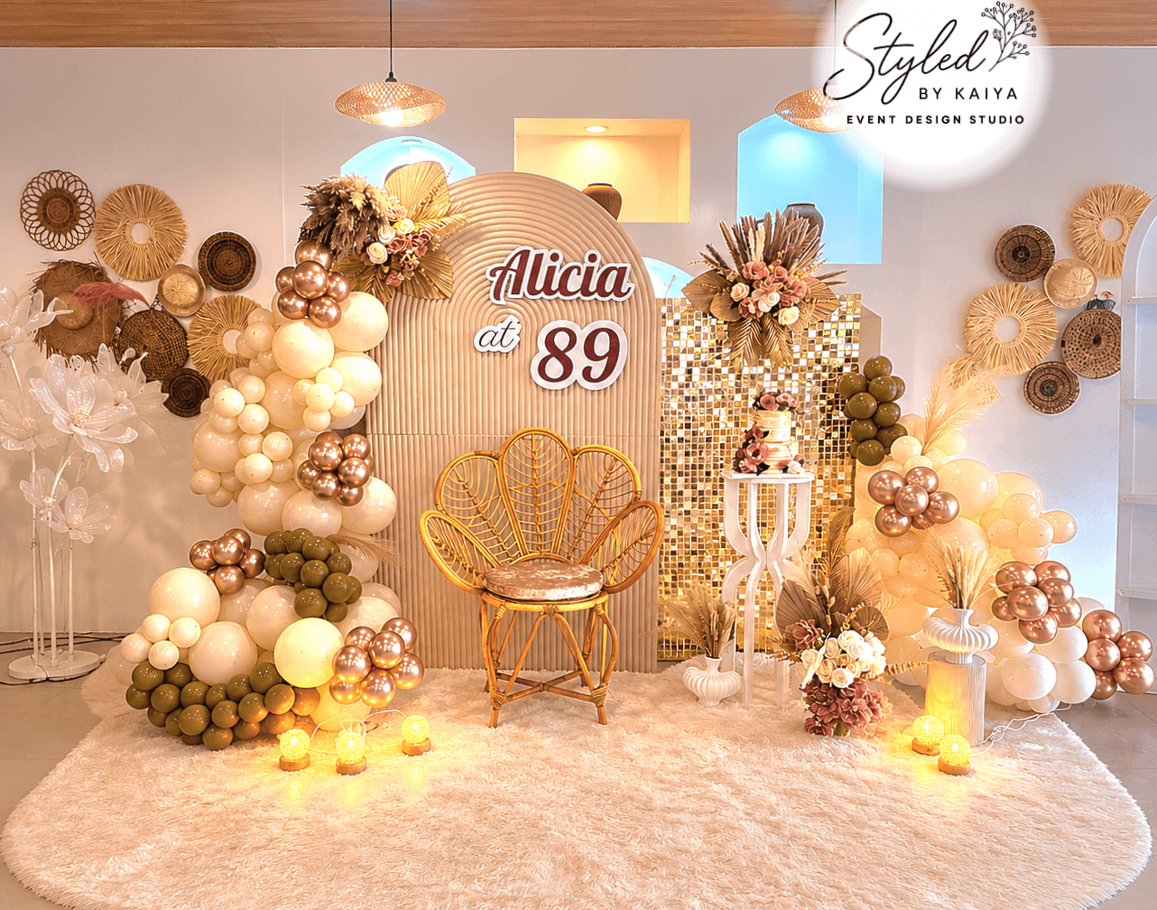 Alicia's 89th birthday full boho setup with gold sequin panel, rattan peacock chair, rose gold balloon arch and pampas grass